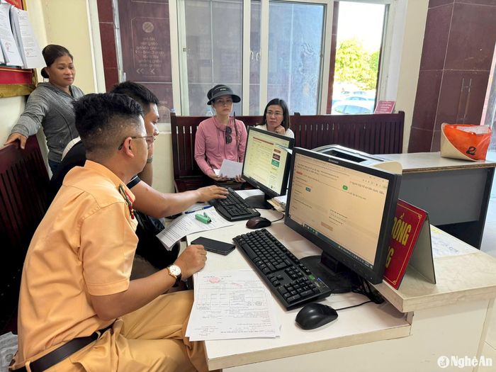 Hiện thủ tục đăng ký xe đã được số hóa nên cao điểm Đội đăng ký xe phải tăng cường cán bộ hỗ trợ người dân nhập thông tin dữ liệu qua Cổng dịch vụ công trực tuyến. Ảnh: Nguyễn Hải