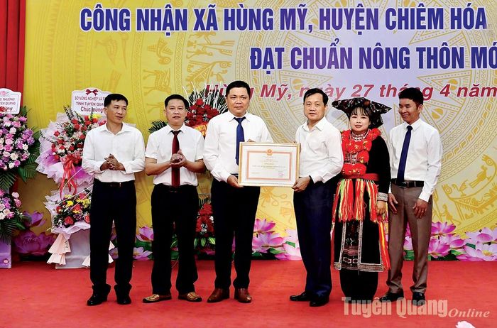 Đồng chí Nguyễn Thế Giang, Ủy viên BCH Đảng bộ tỉnh, Phó Chủ tịch UBND tỉnh trao Bằng công nhận đạt chuẩn nông thôn mới cho lãnh đạo xã Hùng Mỹ (Chiêm Hóa).