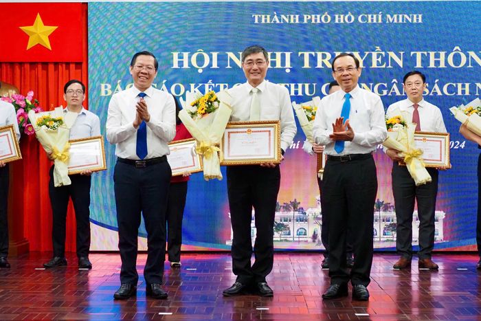Bí thư Thành ủy TPHCM Nguyễn Văn Nên và Chủ tịch UBND TPHCM Phan Văn Mãi trao bằng khen cho lãnh đạo Cục Thuế TPHCM. Ảnh: HOÀNG HÙNG