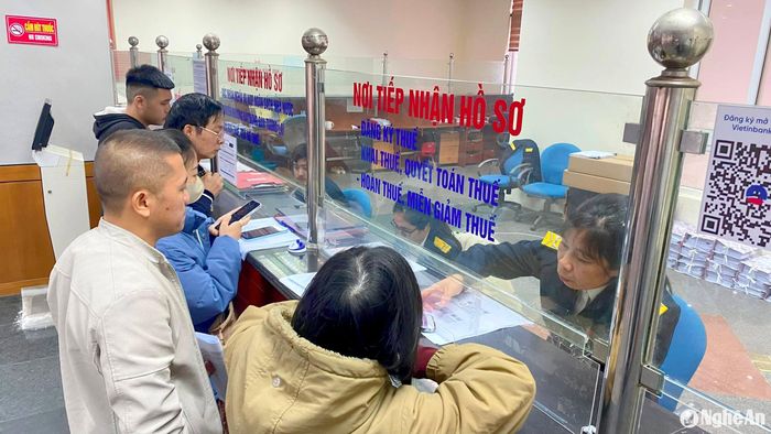 Khu vực tiếp nhận hồ sơ đăng ký thuế, khai thuế, quyết toán thuế, hoàn và miễn giảm thuế, chuyển nhượng bất động sản ở Chi cục Thuế Vinh cũng đông đúc người dân đến làm thủ tục. Ảnh: Quang An