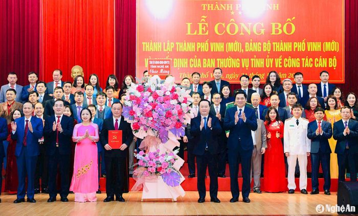 Các đồng chí: Nguyễn Đức Trung - Bí thư Tỉnh ủy, Chủ tịch UBND tỉnh; Hoàng Nghĩa Hiếu - Phó Bí thư Thường trực Tỉnh ủy, Chủ tịch HĐND tỉnh tặng hoa chúc mừng Ban Chấp hành Đảng bộ thành phố Vinh (mới). Ảnh: Phạm Bằng