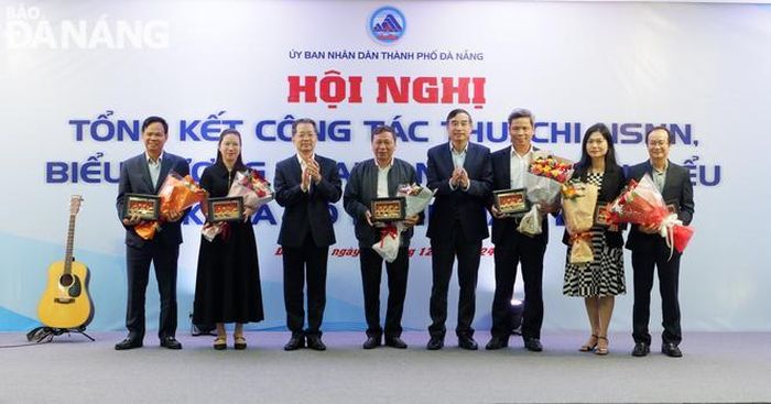 Bí thư Thành ủy Nguyễn Văn Quảng (thứ 3, trái sang) và Chủ tịch UBND thành phố Lê Trung Chinh (thứ 4, phải sang) biểu dương các doanh nghiệp xuất nhập khẩu tiêu biểu. Ảnh: M.QUẾ