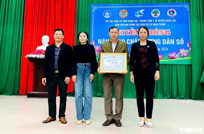 Ông Hoàng Đình Tùng - Chi cục trưởng Chi cục Dân số trao tặng Bằng khen của UBND tỉnh cho chính quyền xã Nghi Thịnh nhờ thực hiện tốt công tác dân số. Ảnh: Mỹ Hà