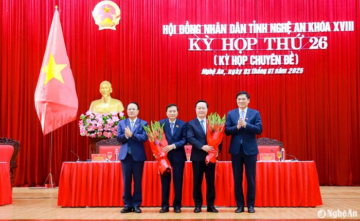 Các đồng chí: Hoàng Nghĩa Hiếu - Phó Bí thư Thường trực Tỉnh ủy, Chủ tịch HĐND tỉnh; Nguyễn Nam Đình - Ủy viên Ban Thường vụ Tỉnh ủy, Phó Chủ tịch Thường trực HĐND tỉnh tặng hoa cảm ơn Bí thư Tỉnh ủy Nguyễn Đức Trung với những cống hiến trên cương vị Chủ tịch UBND tỉnh và chúc mừng đồng chí Lê Hồng Vinh được bầu giữ chức Chủ tịch UBND tỉnh. Ảnh: Thành Duy
