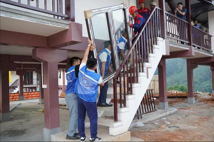 Lắp đặt cửa tái thiết Làng Nủ. Ảnh: Phúc Bảo