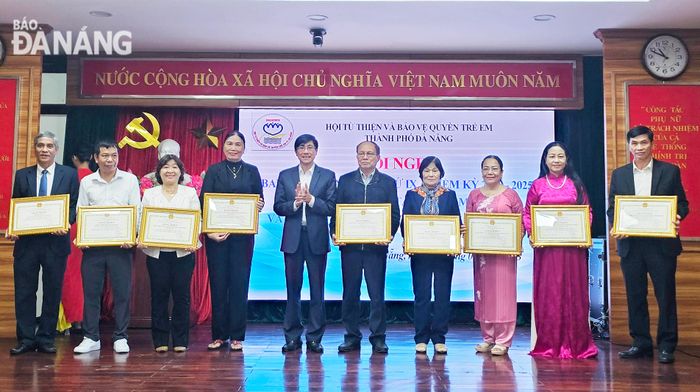 Trưởng Ban Dân vận Thành ủy Trần Thắng Lợi (thứ 5, bên trái qua) trao bằng khen của UBND thành phố cho các tập thể xuất sắc. Ảnh: L.P