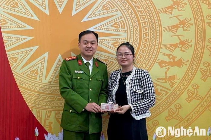 Chị Hồ Thị Lê Na nhận lại số tiền mình chuyển nhầm từ Công an xã Diễn Thịnh sau 2 năm lưu lạc. Ảnh: Hoàng Anh