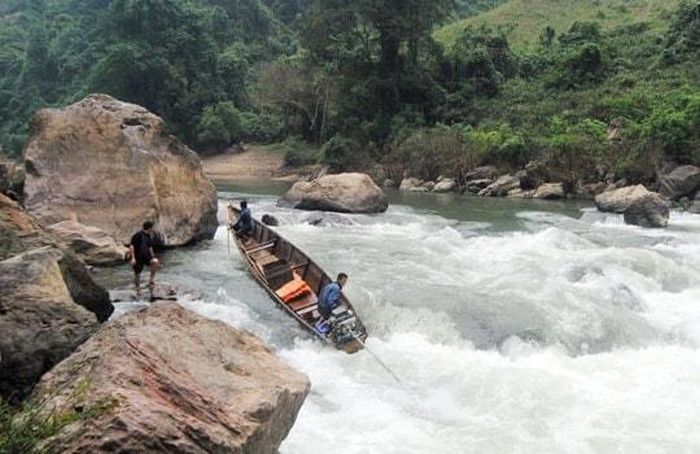Chiếc thuyền nhỏ bé chồm lên khúc sông hung dữ. Ảnh: Tư liệu Công Kiên