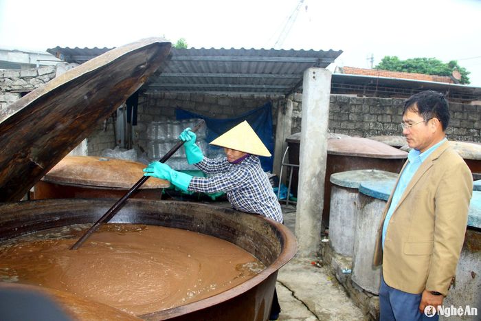 Làng nghề nước mắm Phú Lợi tại phường Quỳnh Dị, T.X Hoàng Mai có khoảng 150 hộ dân làm nghề đang bước vào đợt cao điểm sản xuất hàng Tết. Cá cơm sau khi nhập về sẽ được trộn đều với muối cho vào ủ bể, sau đó lát vỉ nứa lên trên và dùng đá để nén. Để nước mắm được ngon và trong đẹp, cá trong quá trình ủ phải đảo đều. Ảnh: Q.A