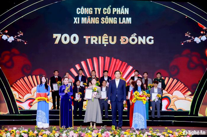 Phó Bí thư Thường trực Tỉnh ủy, Chủ tịch HĐND tỉnh Hoàng Nghĩa Hiếu và Chủ tịch Ủy ban MTTQ Việt Nam tỉnh, Trưởng Đoàn ĐBQH tỉnh Võ Thị Minh Sinh tiếp nhận ủng hộ và trao Giấy chứng nhận tấm lòng nhân ái vì cộng đồng, tặng hoa tri ân Công ty CP Xi măng Sông Lam đã ủng hộ Chương trình "Nghĩa tình dòng Lam - Xuân Ất Tỵ 2025". Ảnh: Thành Duy
