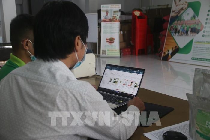 Ông Lâm Ngọc Nhâm (phải), Giám đốc Hợp tác xã Nông nghiệp - Thương mại - Du lịch Bàu Mây, huyện Xuyên Mộc, giới thiệu sản phẩm đang được bán trên sàn thương mại điện tử của tỉnh Bà Rịa-Vũng Tàu. Ảnh: Hoàng Nhị - TTXVN