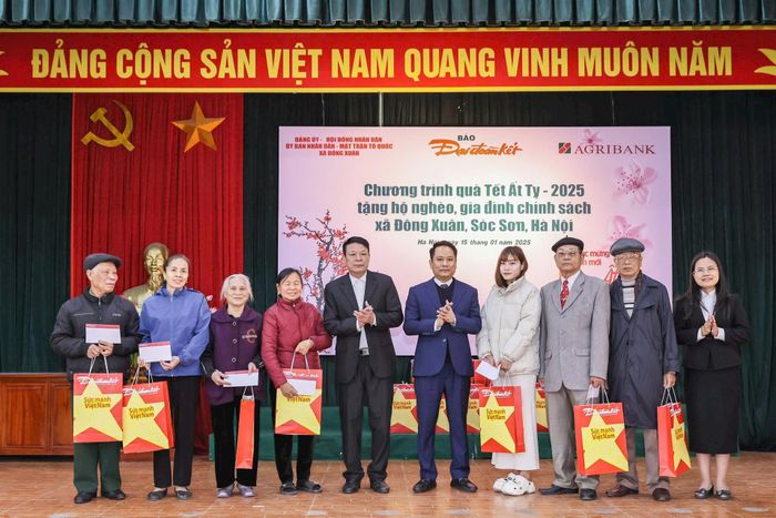Tổng Biên tập Trương Thành Trung và Bí thư Đảng ủy, Chủ tịch HĐND xã Đông Xuân Nguyễn Văn Quá tặng quà cho các gia đình chính sách trên địa bàn xã Đông Xuân.