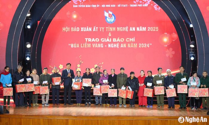 Nhà báo Ngô Đức Kiên - Phó Chủ tịch Hội nhà báo Nghệ An, Tổng Biên tập Báo Nghệ An và bà Nguyễn Thị Lê Na - Giám đốc Công ty Cổ phần Tập đoàn SONA trao quà cho các hộ gia đình có hoàn cảnh khó khăn của thành phố Vinh. Ảnh: Thành Cường