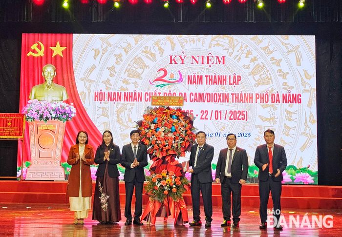 Lãnh đạo thành phố tặng hoa chúc mừng kỷ niệm 20 năm thành lập Hội Nạn nhân chất độc da cam/dioxin thành phố. Ảnh: L.P