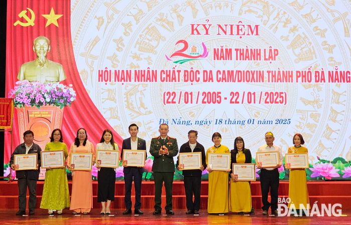 Thiếu tướng Đỗ Hồng Lâm, Phó Chủ tịch Thường trực Trung ương Hội Nạn nhân chất độc da cam/dioxin Việt Nam (giữa) tặng kỷ niệm chương cho các cá nhân. Ảnh: L.P