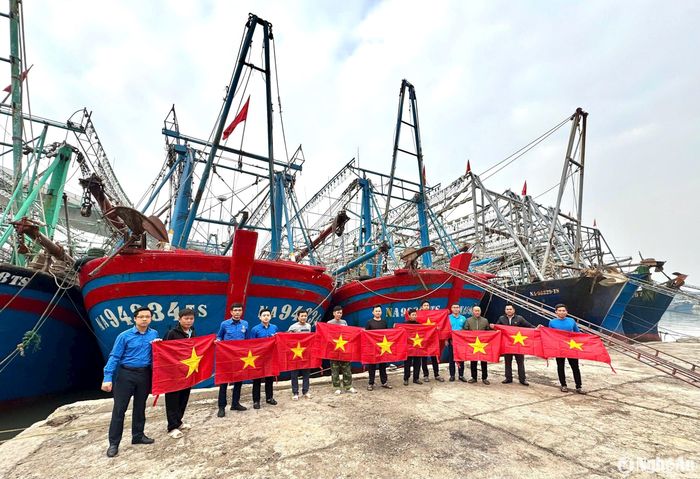 Trao tượng trưng 1.000 cờ Tổ quốc cho ngư dân Quỳnh Lưu tại cảng cá Lạch Quèn. Ảnh: Nguyễn Hải