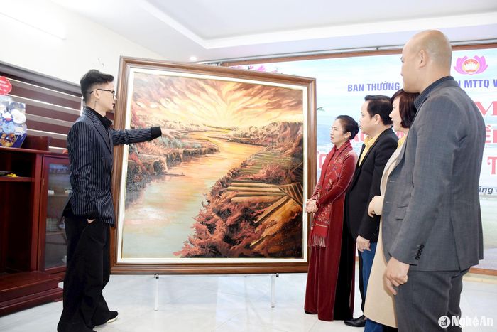 Họa sĩ Bùi Đình Thăng giới thiệu về bức tranh. Ảnh: Công Kiên