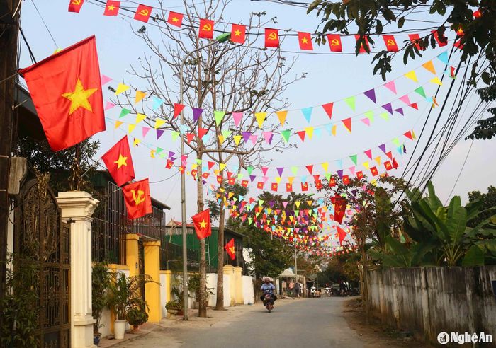 Nhiều tuyến đường được người dân chung tay trang trí kết hợp cờ Tổ quốc, cờ Đảng, cờ xéo... muôn màu tạo nên những cung đường đón Tết lung linh. Ảnh: Huy Thư