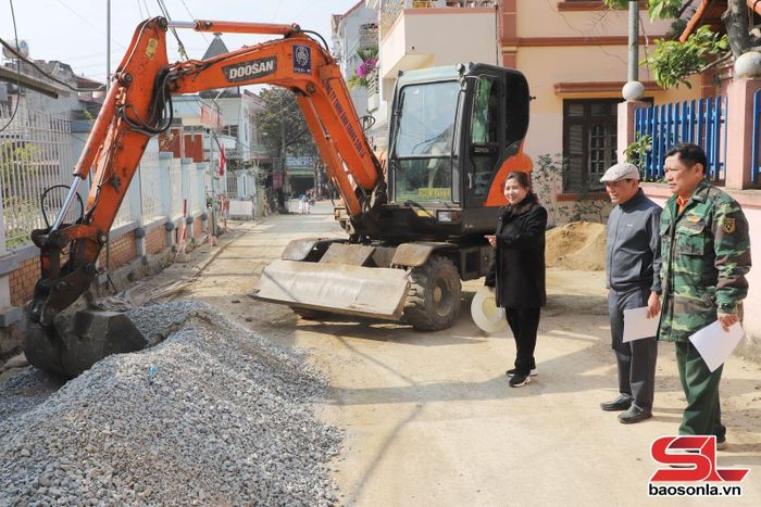 Đồng chí Lê Thị Thúy Hiên, Bí thư chi bộ, Tiểu khu trưởng Tiểu khu 19 cùng nhân dân kiểm tra tiến độ rải nhựa các tuyến đường.