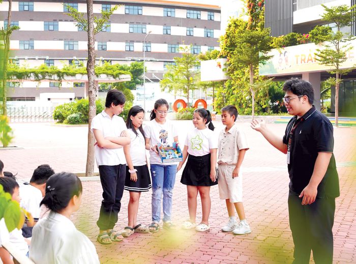 Thầy giáo trẻ Trịnh Quang Thạch (ngoài cùng, bên phải) đang khuyến khích học trò sáng tạo hơn nữa trong học tập. Ảnh: HUỲNH LÊ
