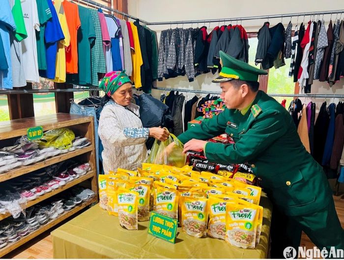 Cán bộ đội Vận động quần chúng Đồn Biên phòng Nậm Càn (Kỳ Sơn) tặng quà Tết cho người dân tại Ngôi nhà thiện nguyện "Ai cần đến lấy - ai có sẻ chia". Ảnh: K.L
