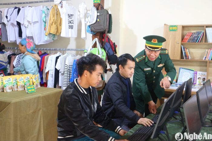 Cán bộ Đội vận động quần chúng Đồn Biên phòng Nậm Càn giúp người dân bản Huồi Nhao truy cập máy tính. Ảnh: KL