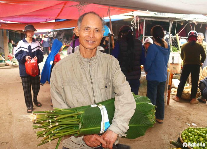 Người đi chợ lựa chọn mua được loại lá dong đẹp, vừa ý. Ảnh: Huy Thư