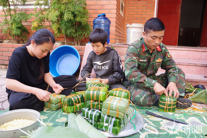 Phụ nữ, thanh niên Lữ đoàn Thông tin 80 cùng các em nhỏ Làng Trẻ em SOS Vinh gói bánh chưng.