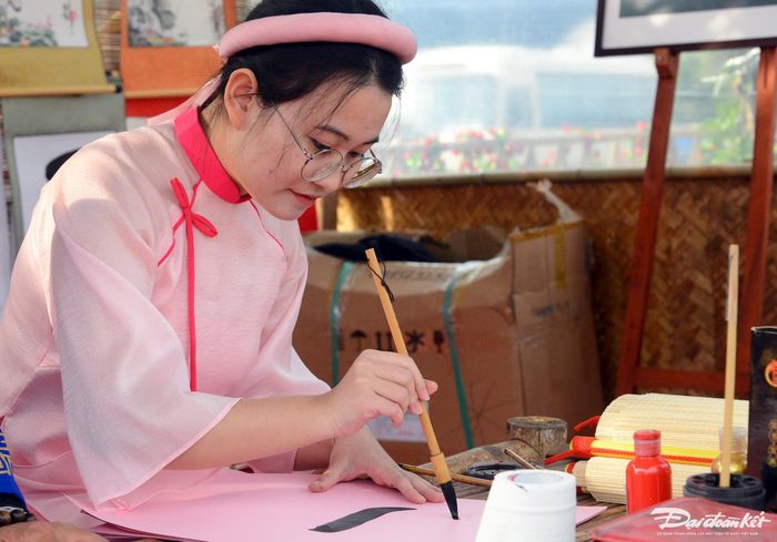 Thiếu nữ chăm chú luyện chữ.