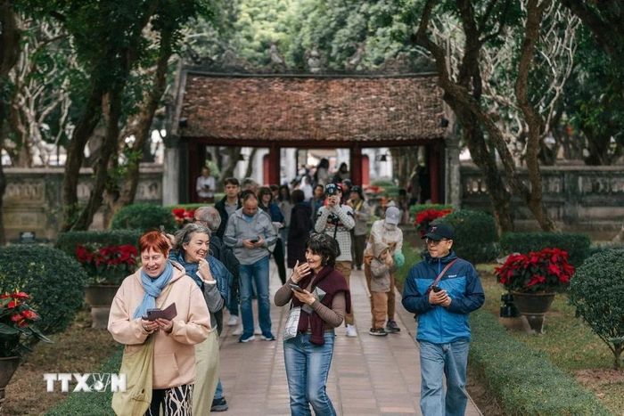 Du khách tìm hiểu về lịch sử tại Văn Miếu-Quốc Tử Giám. (Ảnh: Phạm Tuấn Anh/TTXVN)