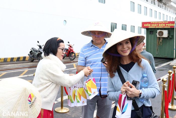 Ngành du lịch thành phố tặng quà lưu niệm cho du khách "xông đất" Đà Nẵng. Ảnh: HOÀNG HIỆP