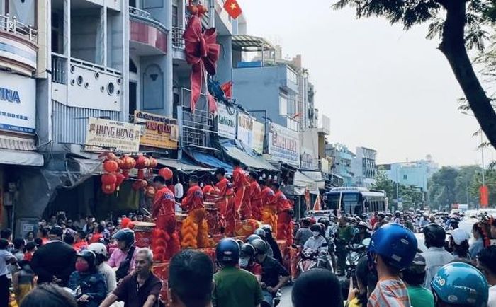 Nghe tiếng trống lân, dù đang đi chúc Tết nhiều người vẫn nán lại xem.