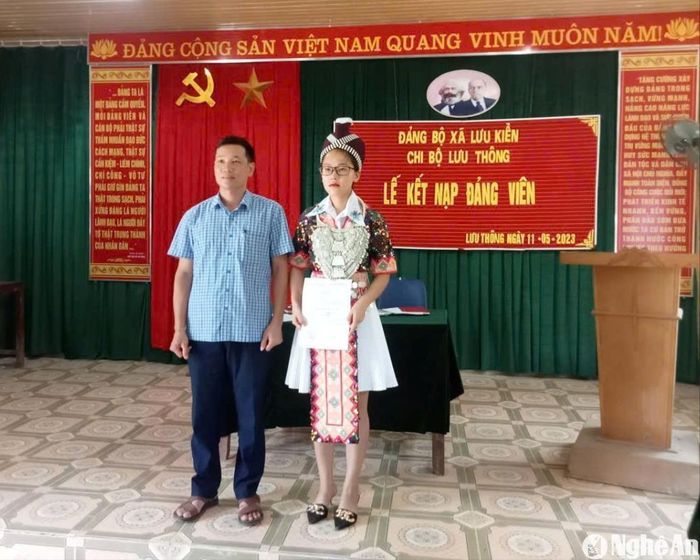 Đảng viên trẻ người Mông Vừ Thị Thu Trang chụp ảnh với Phó Bí thư trực Đảng xã Lưu Kiền Lữ Văn Hải tại lễ kết nạp đảng viên. Ảnh: CSCC