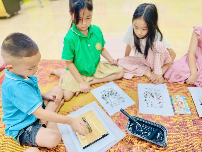 Các em nhỏ trải nghiệm làm tranh Đông Hồ tại Bảo tàng Nghệ An. Ảnh: Minh Quân