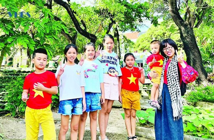 Tác giả chụp ảnh cùng các em bé ở đảo Sinh Tồn.