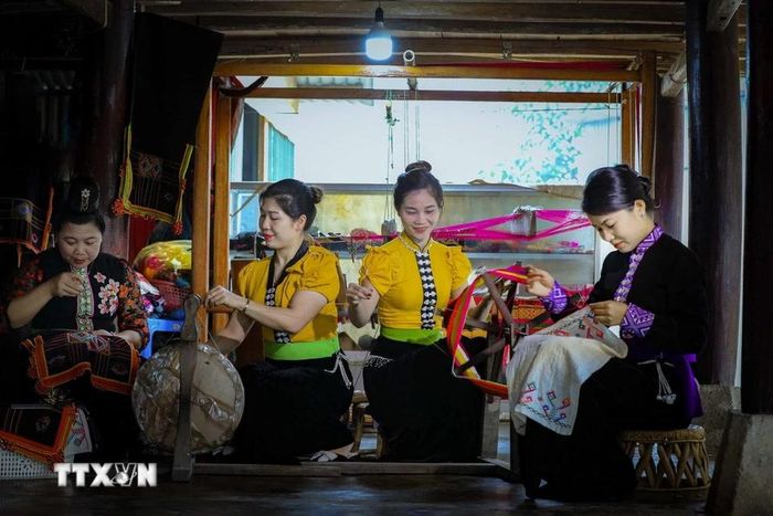 Những phụ nữ dân tộc Thái thêu trang phục dân tộc. (Ảnh: Xuân Tư/TTXVN)