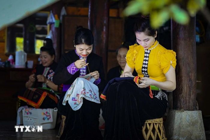 Thiếu nữ dân tộc Thái thêu trang phục truyền thống. (Ảnh: Xuân Tư/TTXVN)