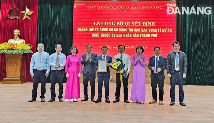 Lãnh đạo Đảng ủy Khối các cơ quan thành phố tặng hoa và trao quyết định cho Ban chấp hành Đảng bộ Ban Quản lý các dự án đầu tư cơ sở hạ tầng ưu tiên thành phố Đà Nẵng. Ảnh: THÀNH LÂN