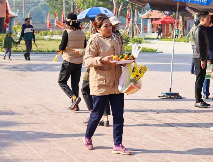 Một du khách cúng lễ với hoa quả, hương, hoa với rất ít vàng mã. Ảnh: Minh Quân