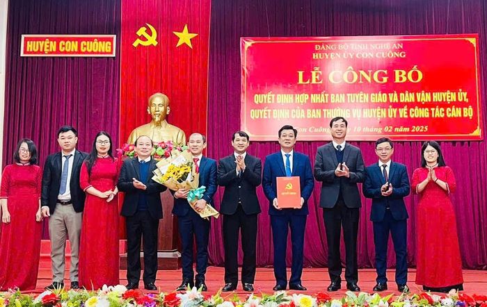 Lãnh đạo huyện trao quyết định hợp nhất và tặng hoa chúc mừng Ban Tuyên giáo và Dân vận Huyện ủy Con Cuông. Ảnh: Tường Vi