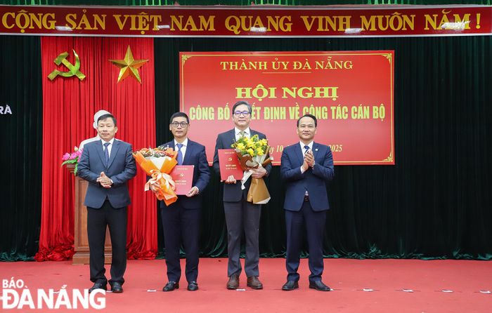 Phó Bí thư Thường trực Thành ủy Nguyễn Đình Vĩnh (bên phải) trao quyết định và Trưởng ban Tổ chức Thành ủy Đoàn Duy Tân (bên trái) tặng hoa chúc mừng đồng chí Phạm Trường Sơn và đồng chí Phùng Phú Phong. Ảnh: NGỌC PHÚ