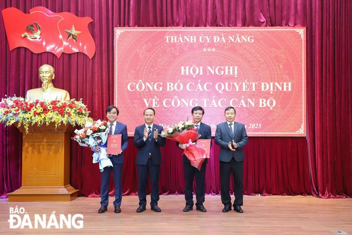 Phó Bí thư Thường trực Thành ủy Nguyễn Đình Vĩnh (thứ 2, trái sang) trao quyết định và Trưởng ban Tổ chức Thành ủy Đoàn Duy Tân (bên phải) tặng hoa chúc mừng đồng chí Tô Văn Hùng và đồng chí Bùi Hồng Trung. Ảnh: NGỌC PHÚ
