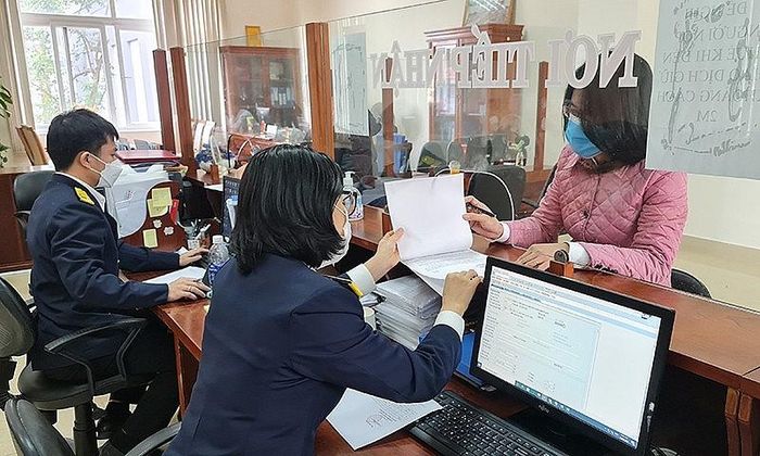 Công chức Cục Thuế Quảng Bình hỗ trợ người nộp thuế. Ảnh: CTV.