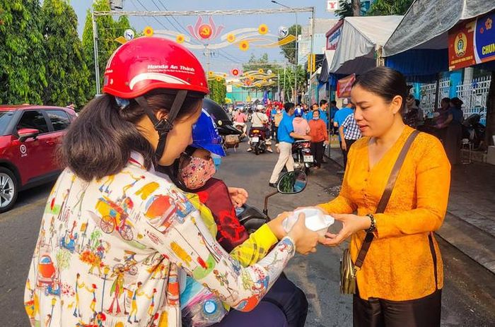 Một người dân tham gia vào các nhóm thiện nguyện phát đồ ăn miễn phí cho du khách hành hương 