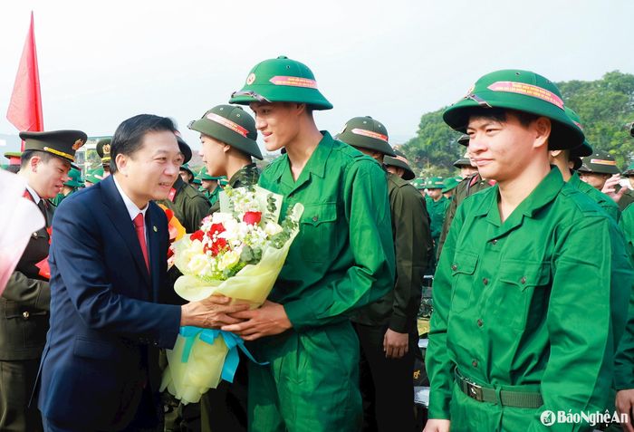 Đồng chí Lê Hồng Vinh - Phó Bí thư Tỉnh ủy, Chủ tịch UBND tỉnh, Chủ tịch Hội đồng Nghĩa vụ quân sự tỉnh tặng hoa chúc mừng các thanh niên ưu tú huyện Nam Đàn trúng tuyển nghĩa vụ quân sự. Ảnh: Thành Duy