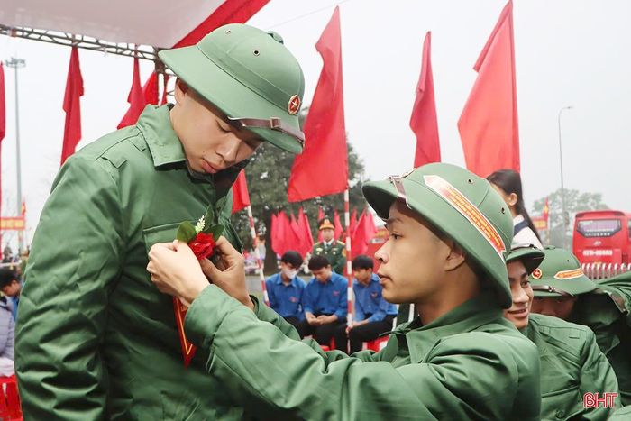 Tân binh giúp nhau chỉnh đốn trang phục trước lúc lên đường tòng quân, mang theo niềm kiêu hãnh của tuổi trẻ... 