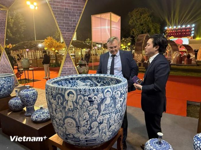  Khách tham quan tìm hiểu về sản phầm của làng gốm Bát Tràng. (Ảnh: PV/Vietnam+) 