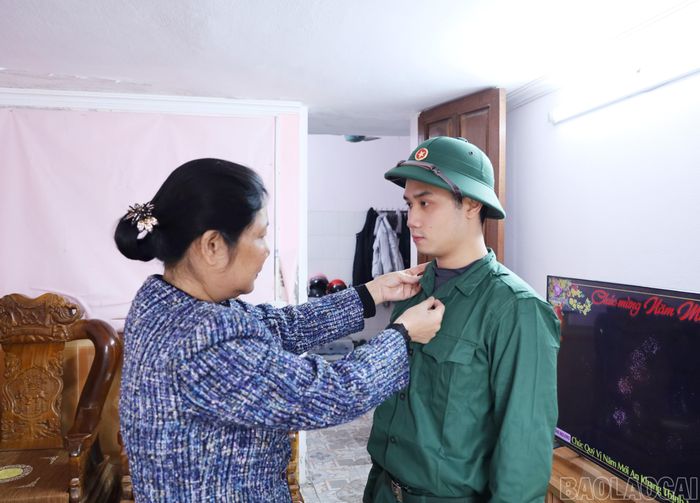  Bà Bùi Thị Thu (mẹ Hậu) chỉnh quân phục cho con trai chuẩn bị nhập ngũ. 