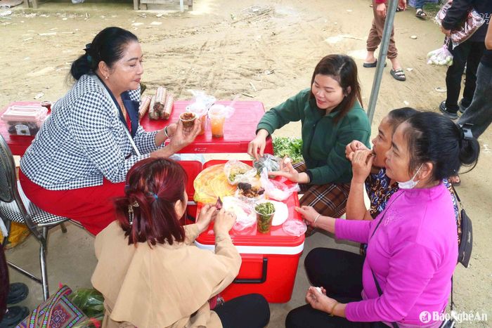 Giữa phiên chợ, người dân có thể chọn mua quà bánh như xôi, thịt bò giàng, bún... ngồi quây quần nói chuyện vui vẻ, thưởng thức món ăn khi còn nóng sốt. Ảnh: Huy Thư