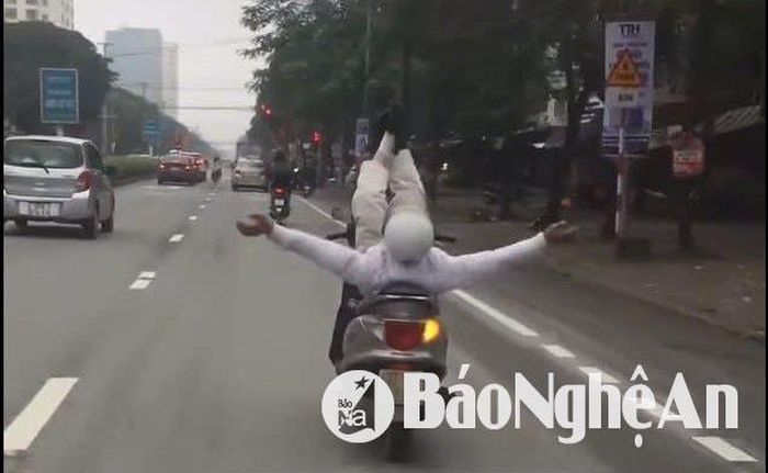 Hình ảnh người đàn ông giơ cả hai tay và hai chân lên trời để mặc xe máy di chuyển tự do. Ảnh cắt từ clip